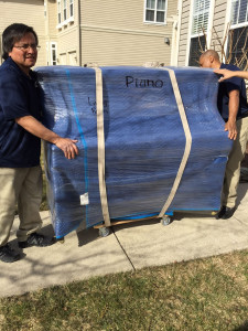 Movers moving a Piano